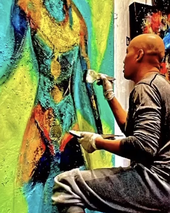 Andre Kowlessar painting a large abstract figure work in his studio